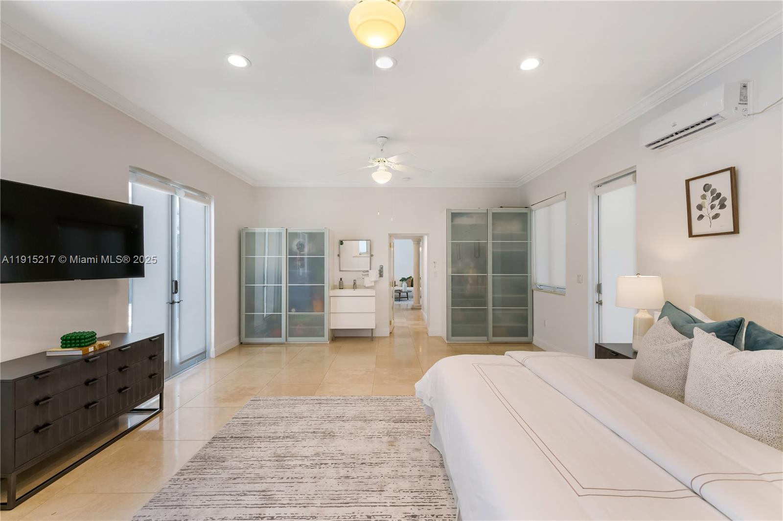 8941 Southwest 65th Court, Unit 8941 Pinecrest, FL 33156 - Photo 47 of 85 a spacious bedroom with a large bed and a flat screen tv