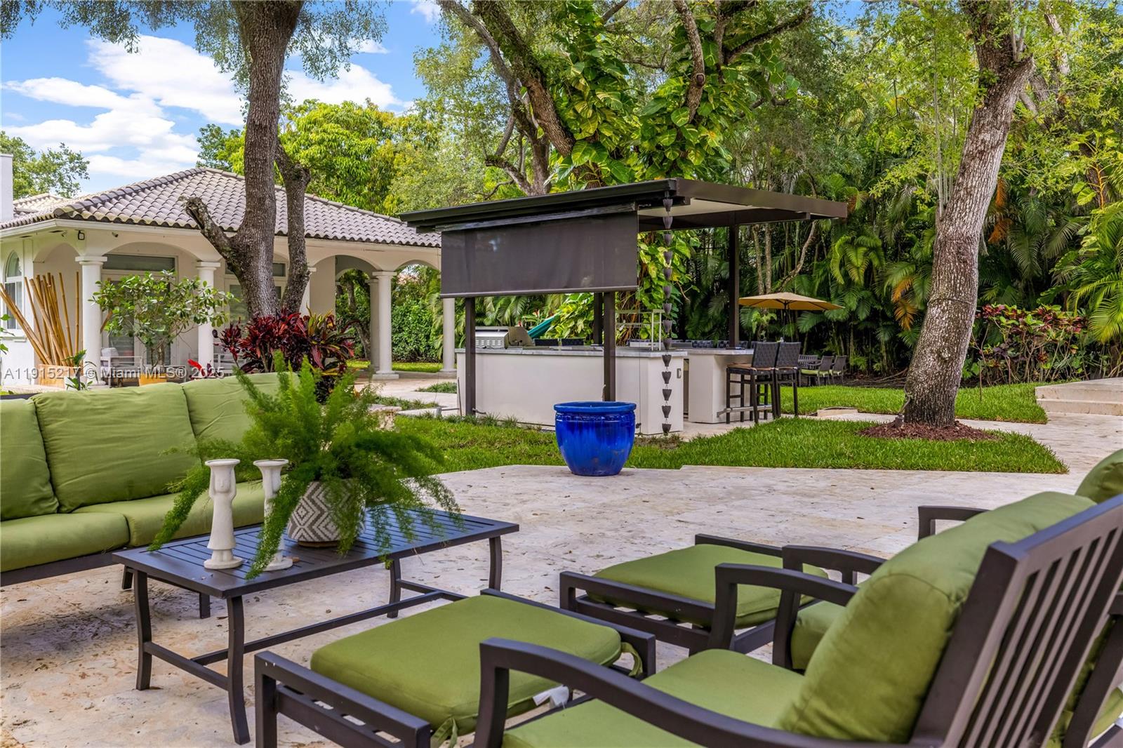 8941 Southwest 65th Court, Unit 8941 Pinecrest, FL 33156 - Photo 54 of 85 a view of a patio with couches table and chairs with wooden fence and plants