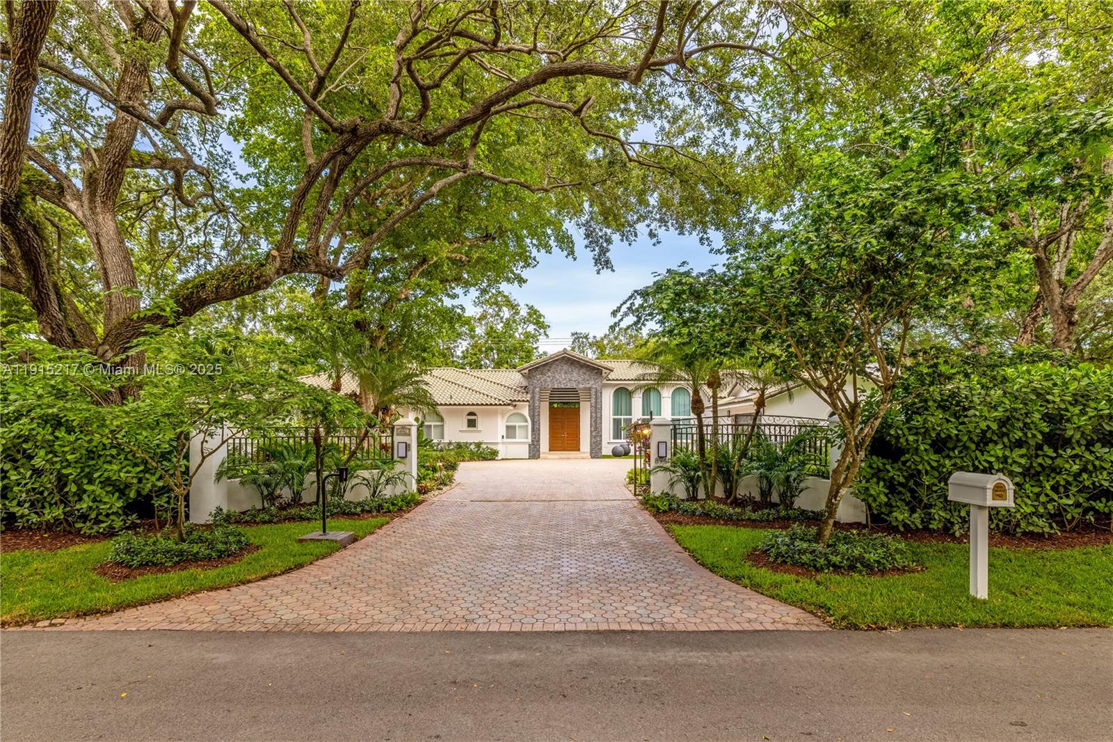 8941 Southwest 65th Court, Unit 8941 Pinecrest, FL 33156 - Photo 71 of 85 a front view of a house with a yard and trees