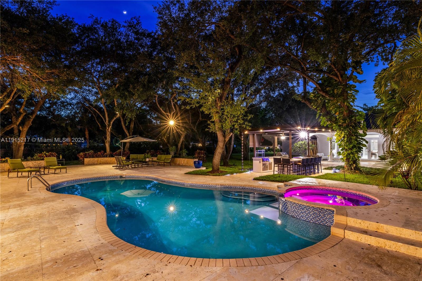 8941 Southwest 65th Court, Unit 8941 Pinecrest, FL 33156 - Photo 78 of 85 a view of a swimming pool with a fire pit and trees