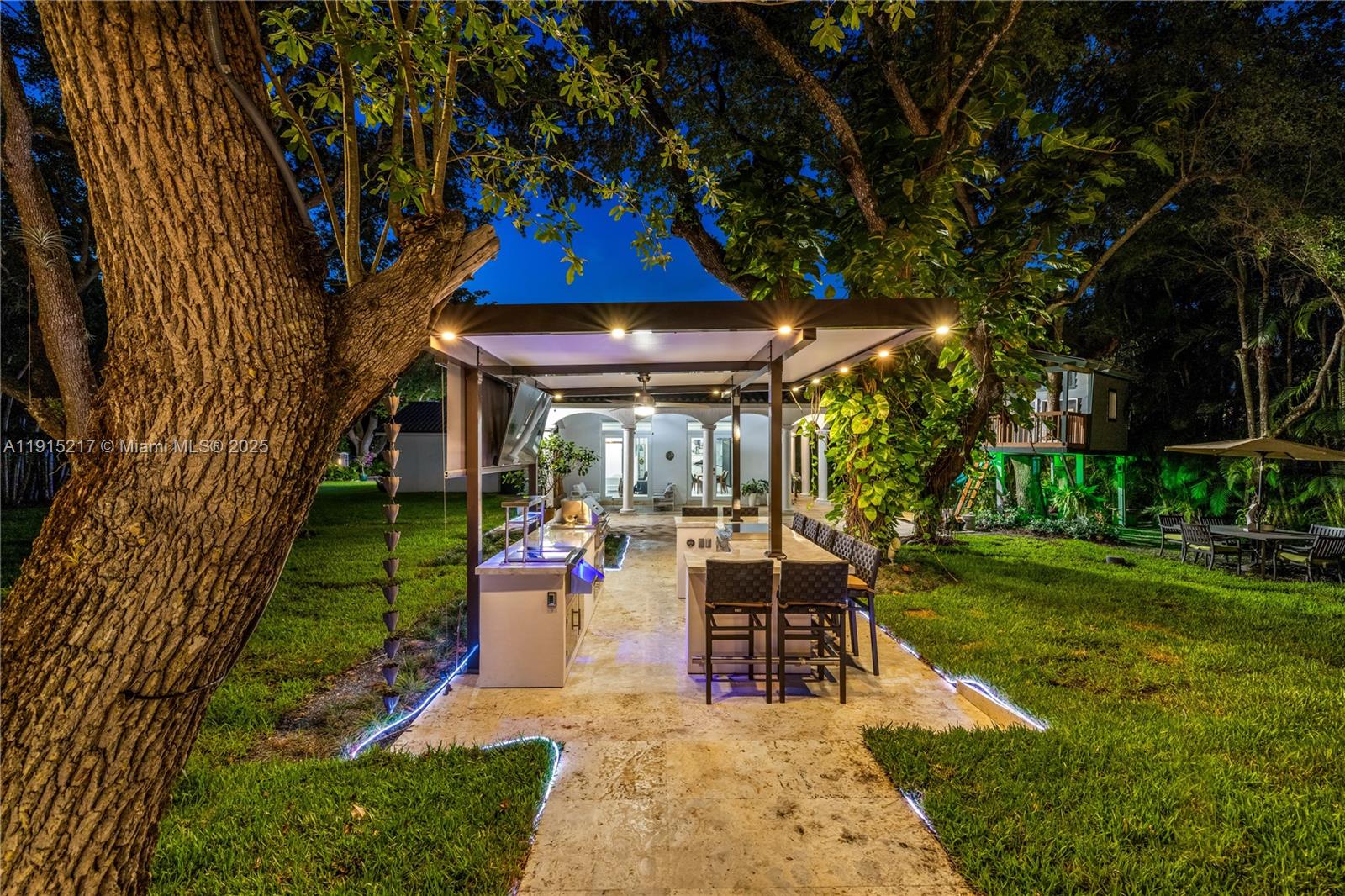 8941 Southwest 65th Court, Unit 8941 Pinecrest, FL 33156 - Photo 80 of 85 a view of a patio with table and chairs under an umbrella