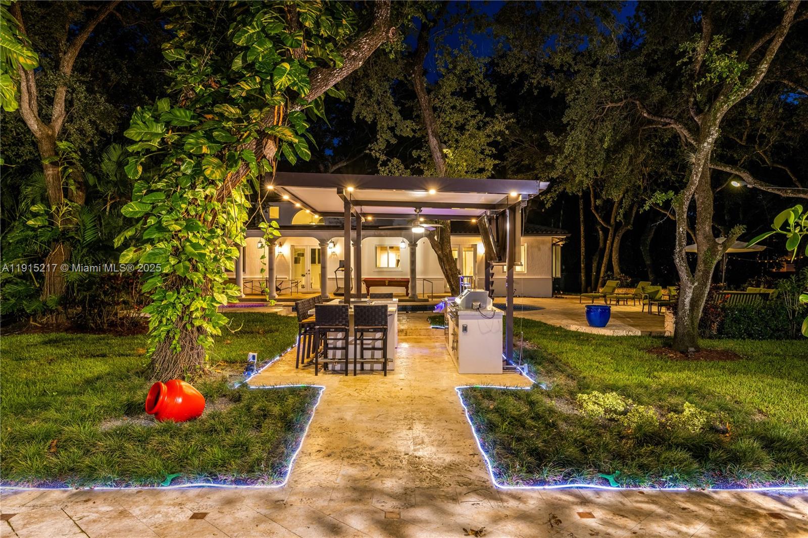8941 Southwest 65th Court, Unit 8941 Pinecrest, FL 33156 - Photo 83 of 85 a view of swimming pool with a table and chairs in patio
