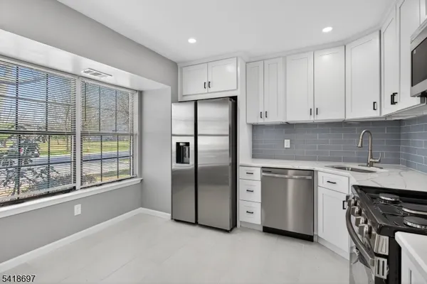 a kitchen with stainless steel appliances granite countertop a refrigerator and a stove top oven
