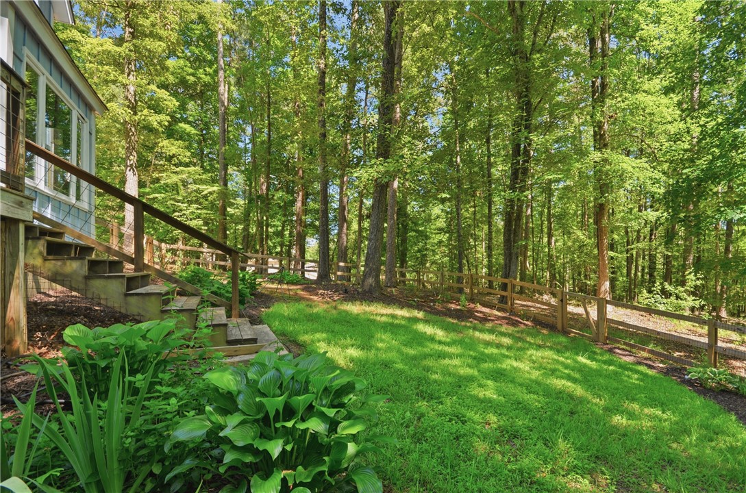 1298 Carradine Road Seneca, SC 29678 - Photo 34 of 43 A tranquil wooded landscape surrounds a fenced-in grassed yard.