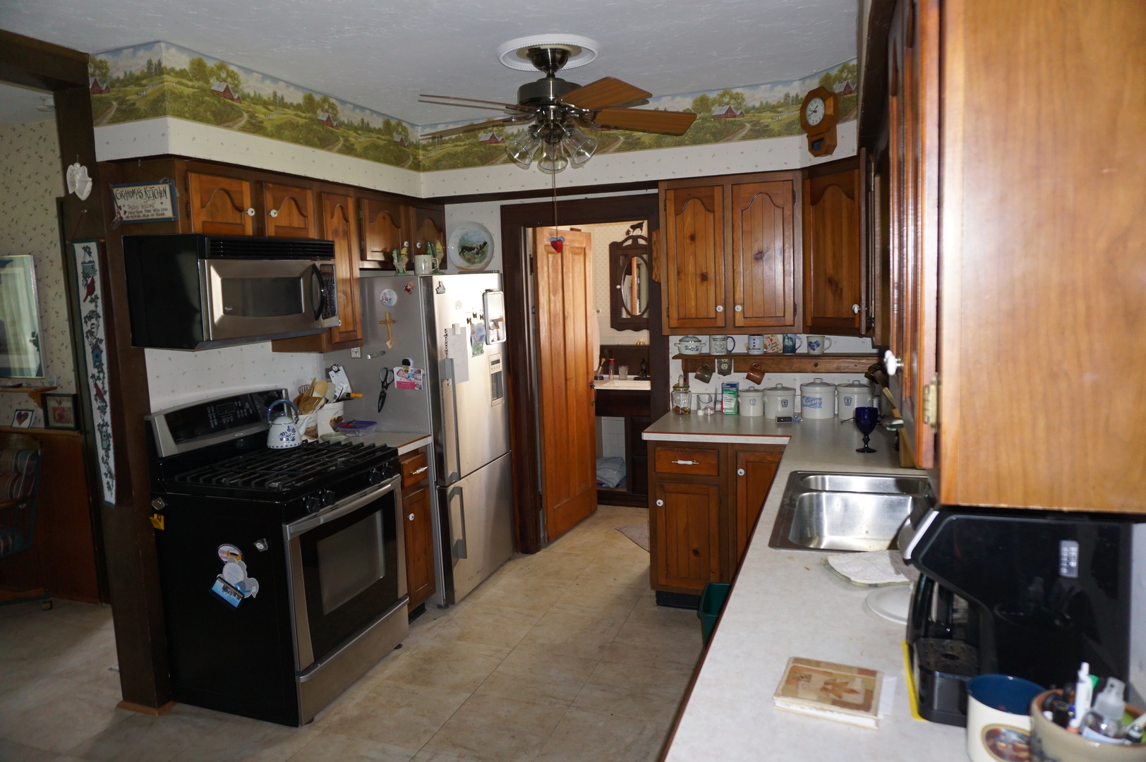 1924 East 6000th Road South St. Anne, IL 60964 - Photo 7 of 35 a kitchen with stainless steel appliances granite countertop a refrigerator a stove and a sink with wooden cabinets