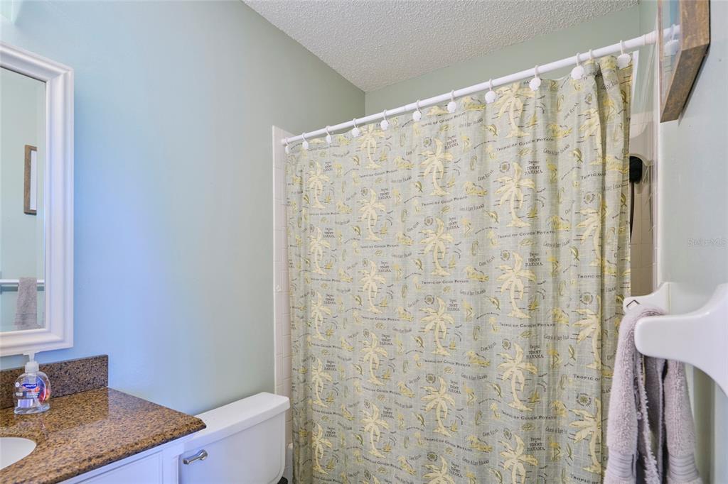 3647 Edgewater Drive Sebring, FL 33872 - Photo 33 of 54 a bathroom with a granite countertop sink a mirror and a shower curtain