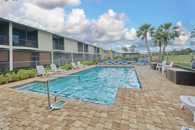 a view of a white house with a yard and potted plants