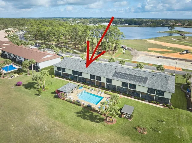 an aerial view of a house with a yard and lake view