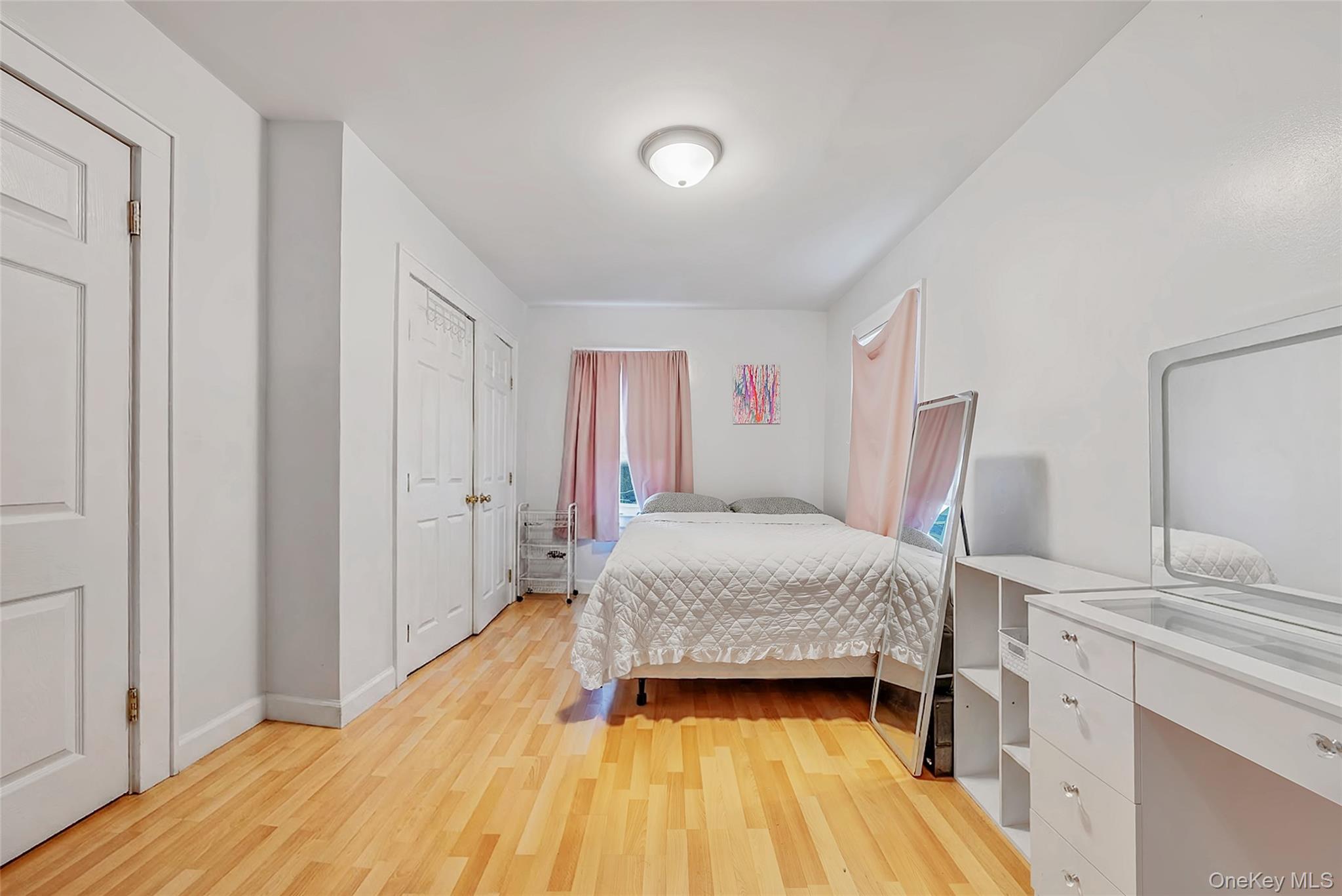 80 George Street Babylon, NY 11702 - Photo 33 of 41 a bedroom with a bed and wooden floor