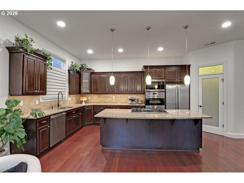 3356 Northwest 153rd Terrace Portland, OR 97229 - Photo 9 of 24 a large kitchen with stainless steel appliances granite countertop a sink a stove and a wooden floors