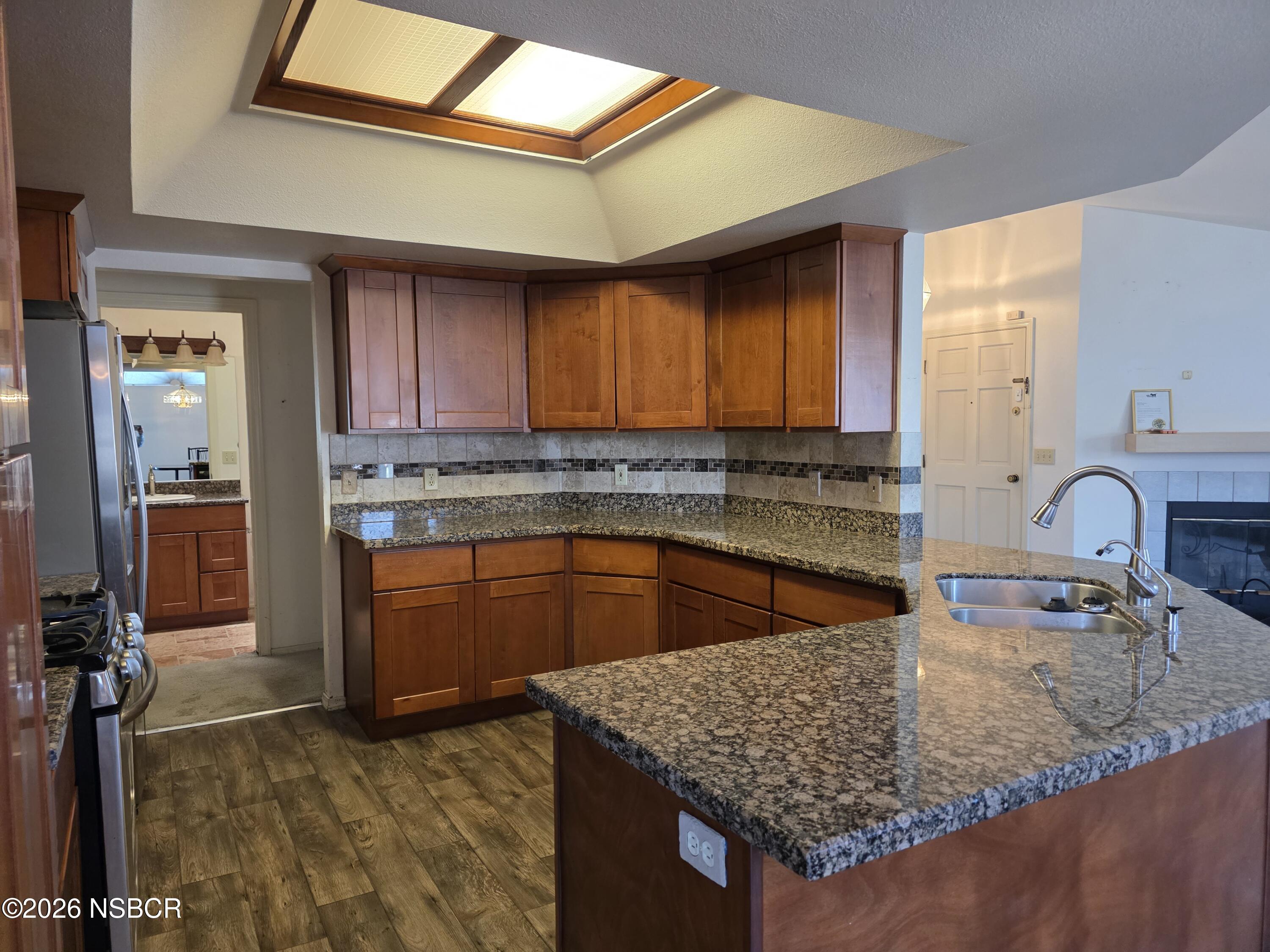 1112 Rachel Drive Santa Maria, CA 93454 - Photo 6 of 23 a kitchen with kitchen island granite countertop a sink a counter top space and cabinets