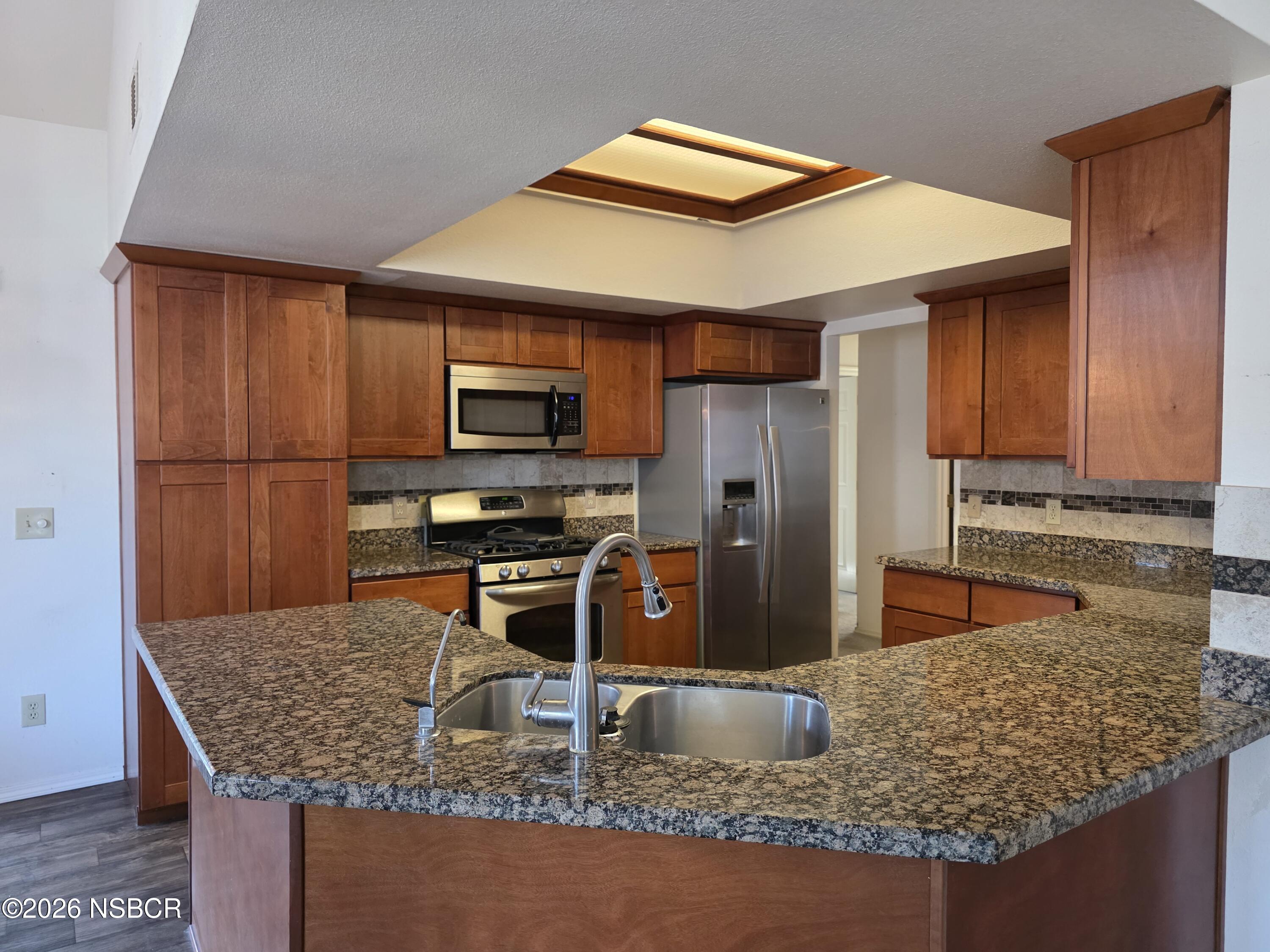 1112 Rachel Drive Santa Maria, CA 93454 - Photo 7 of 23 a kitchen with stainless steel appliances granite countertop a sink refrigerator and microwave