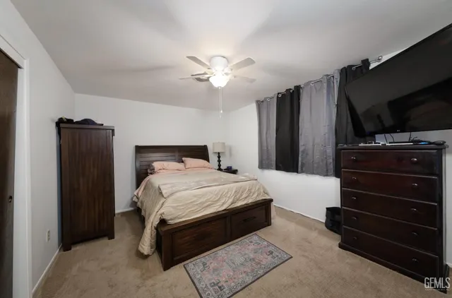 a bedroom with a bed and a flat tv screen on wall