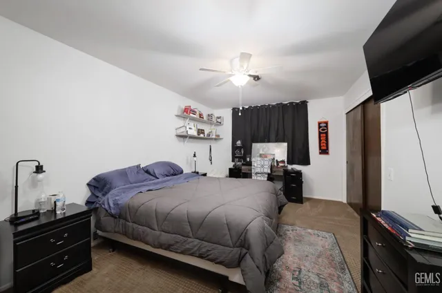 a bedroom with a bed dresser and a flat tv screen