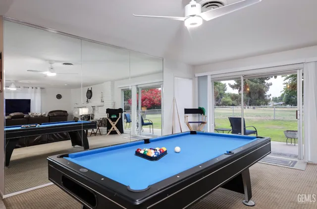 a room with furniture pool table flat screen tv and a large window