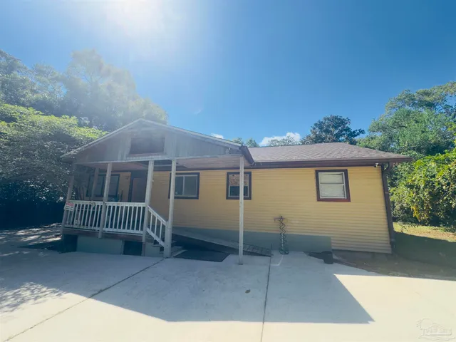 a view of a house with a yard and wooden fence