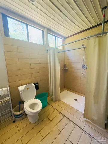 a bathroom with a toilet and a shower