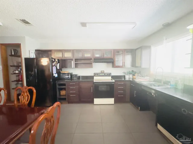 a kitchen with stainless steel appliances granite countertop a refrigerator sink and stove