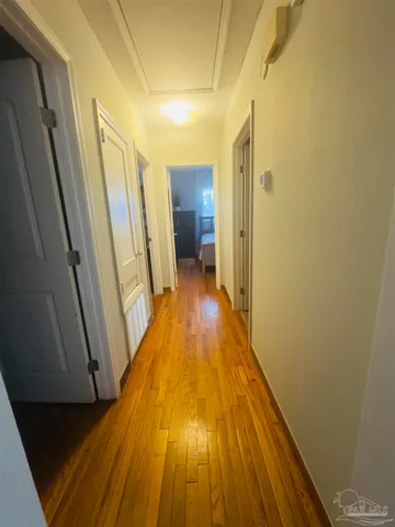 a view of a hallway with wooden floor