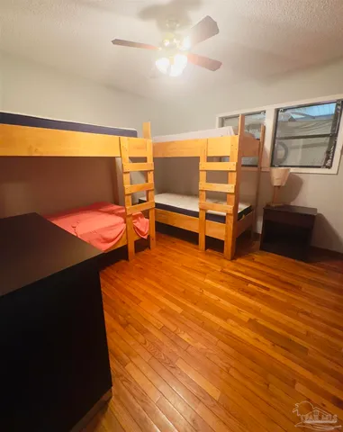 a bedroom with wooden floor and window