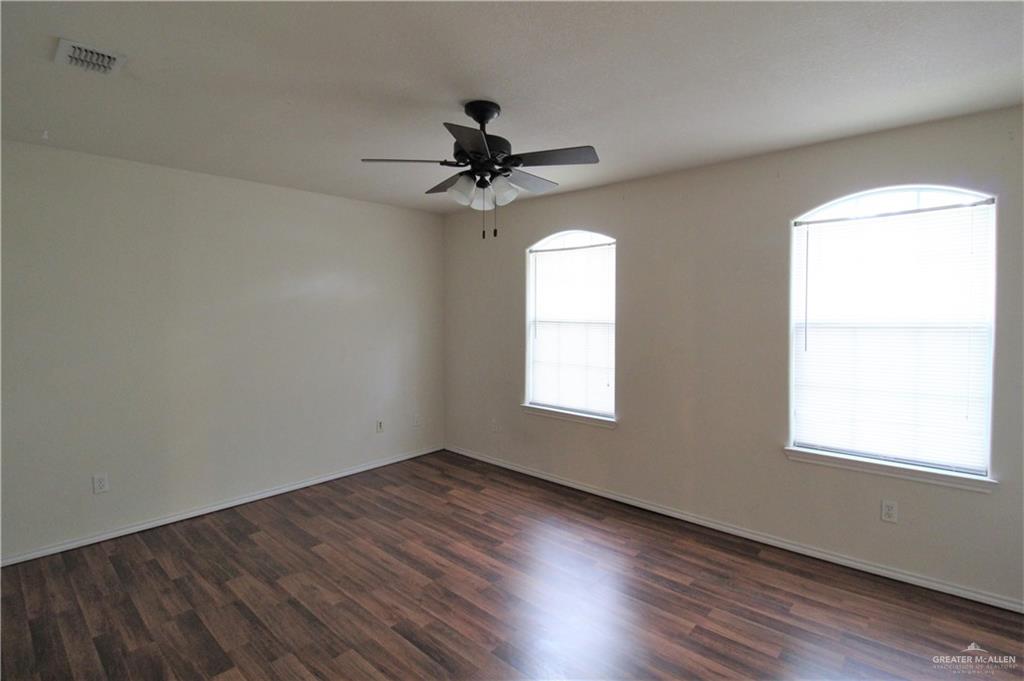 8202 North 22nd Lane McAllen, TX 78504 - Photo 19 of 25 an empty room with wooden floor fan and windows