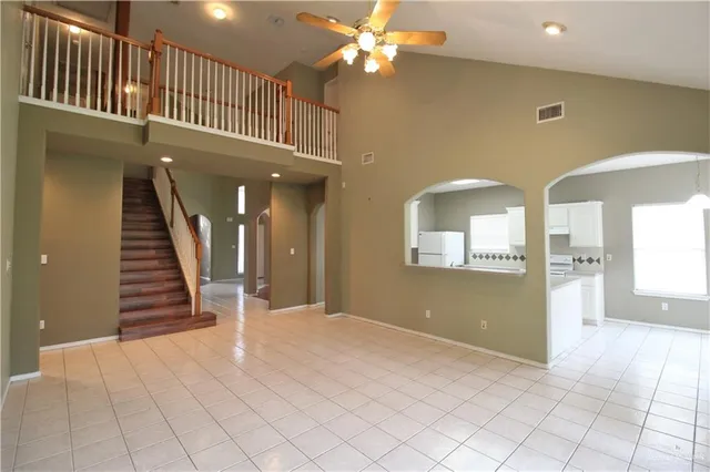 an entryway in a hall with a window and a chandelier