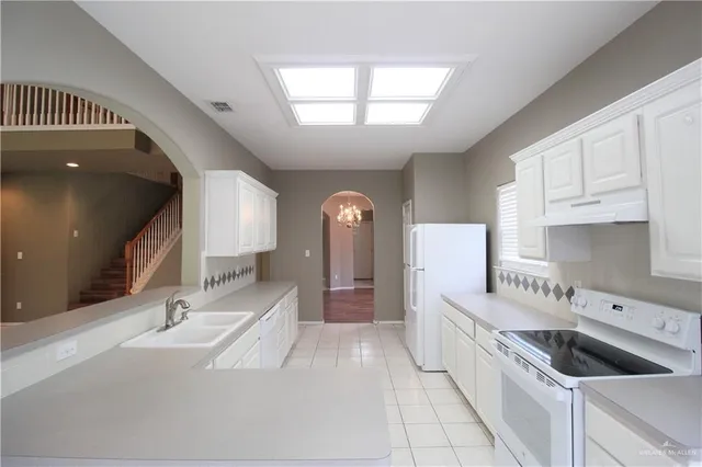 a large white kitchen with a large window