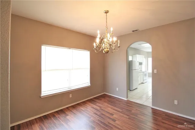 a view of a room with wooden floor and chandelier