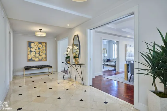 a dining room with furniture a rug and potted plants
