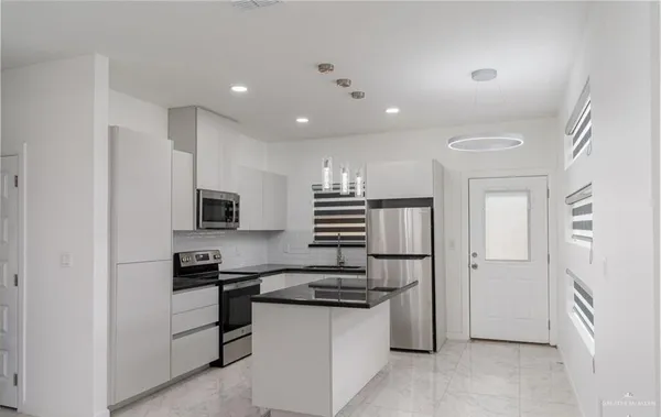 a kitchen with cabinets and stainless steel appliances