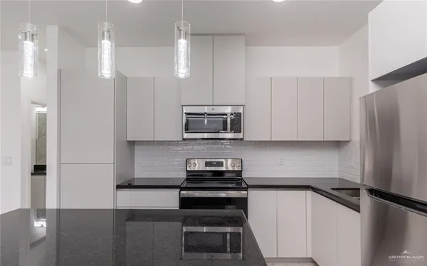 a kitchen with a refrigerator and a stove top oven