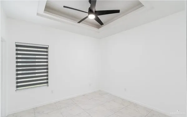 an empty room with a ceiling fan and carpet
