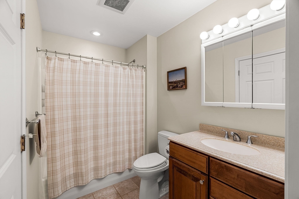 28 Van Norden Road Woburn, MA 01801 - Photo 18 of 24 a bathroom with a sink vanity mirror and toilet