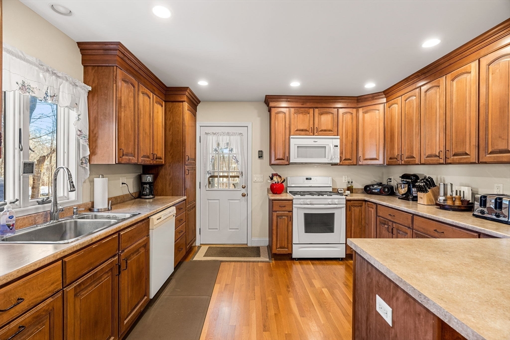 28 Van Norden Road Woburn, MA 01801 - Photo 7 of 24 a kitchen with stainless steel appliances granite countertop a stove top oven a sink dishwasher a refrigerator and cabinets with wooden floor