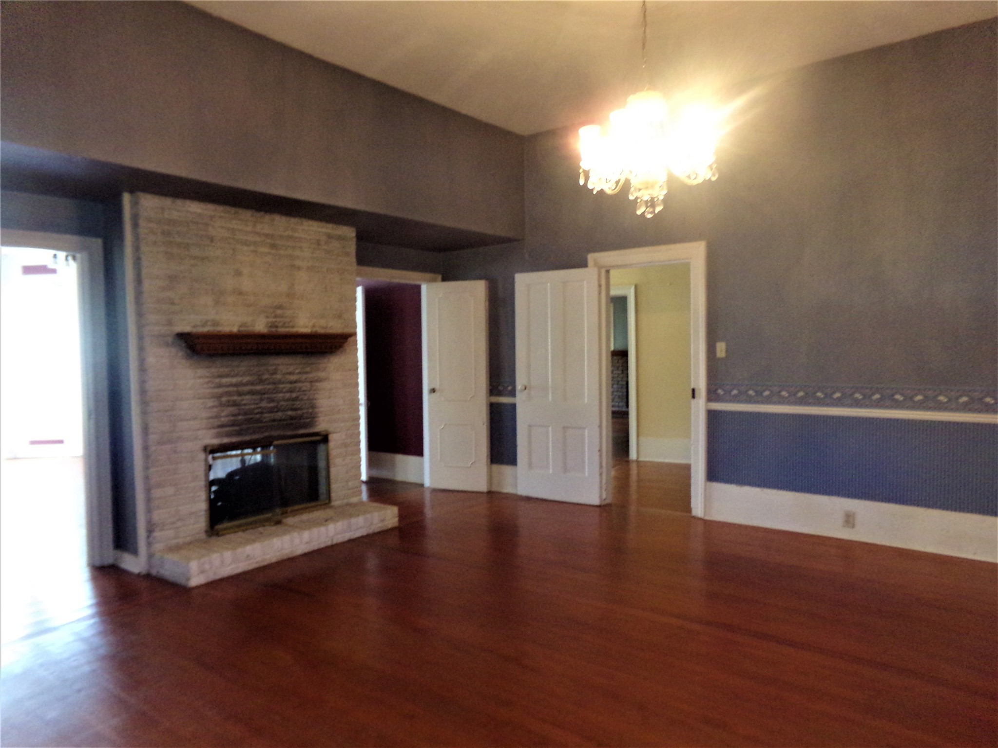 300 South Summit Street Weimar, TX 78962 - Photo 11 of 27 a view of an empty room with wooden floor and a fire place