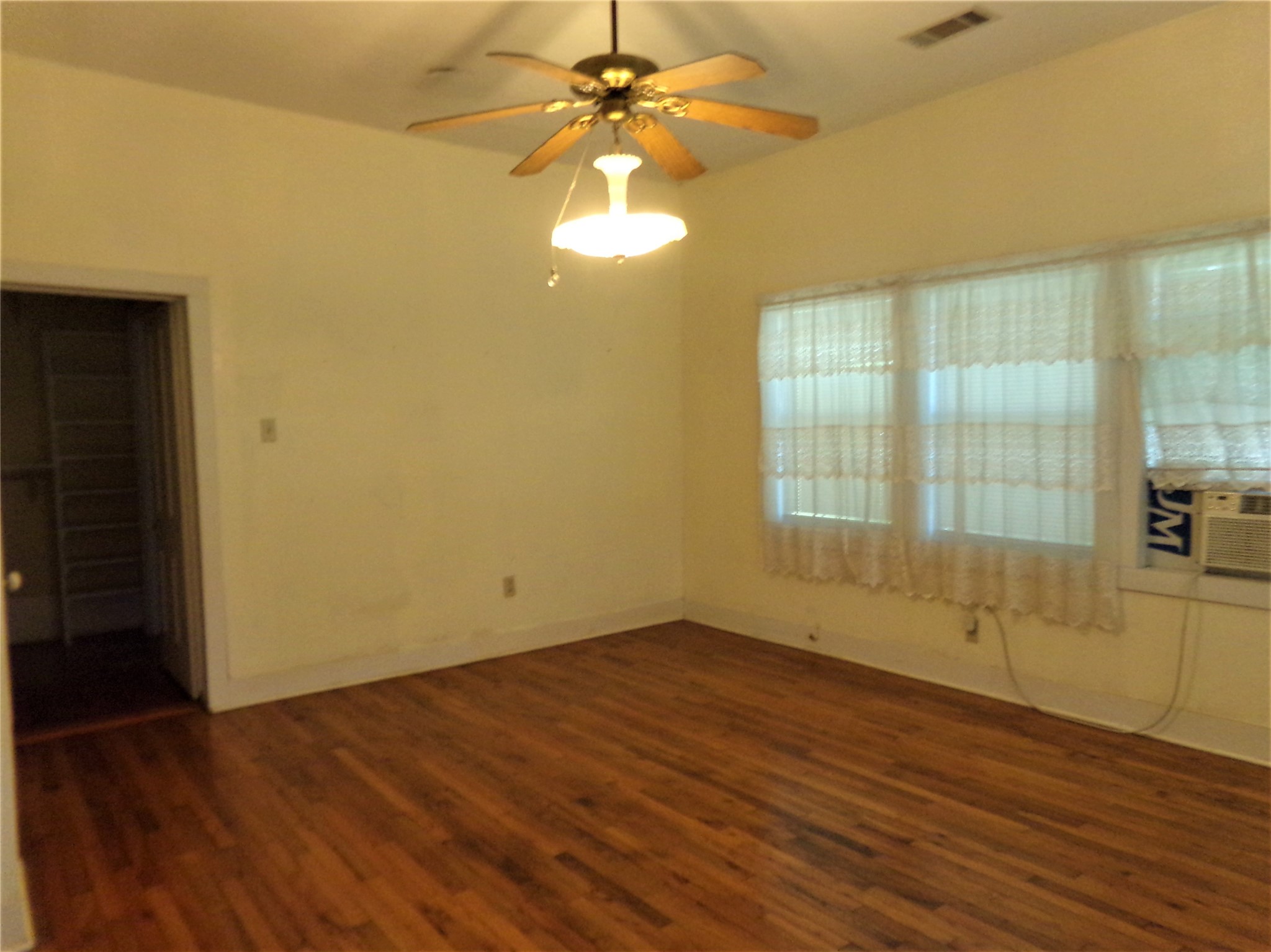 300 South Summit Street Weimar, TX 78962 - Photo 17 of 27 a view of an empty room with wooden floor and a window