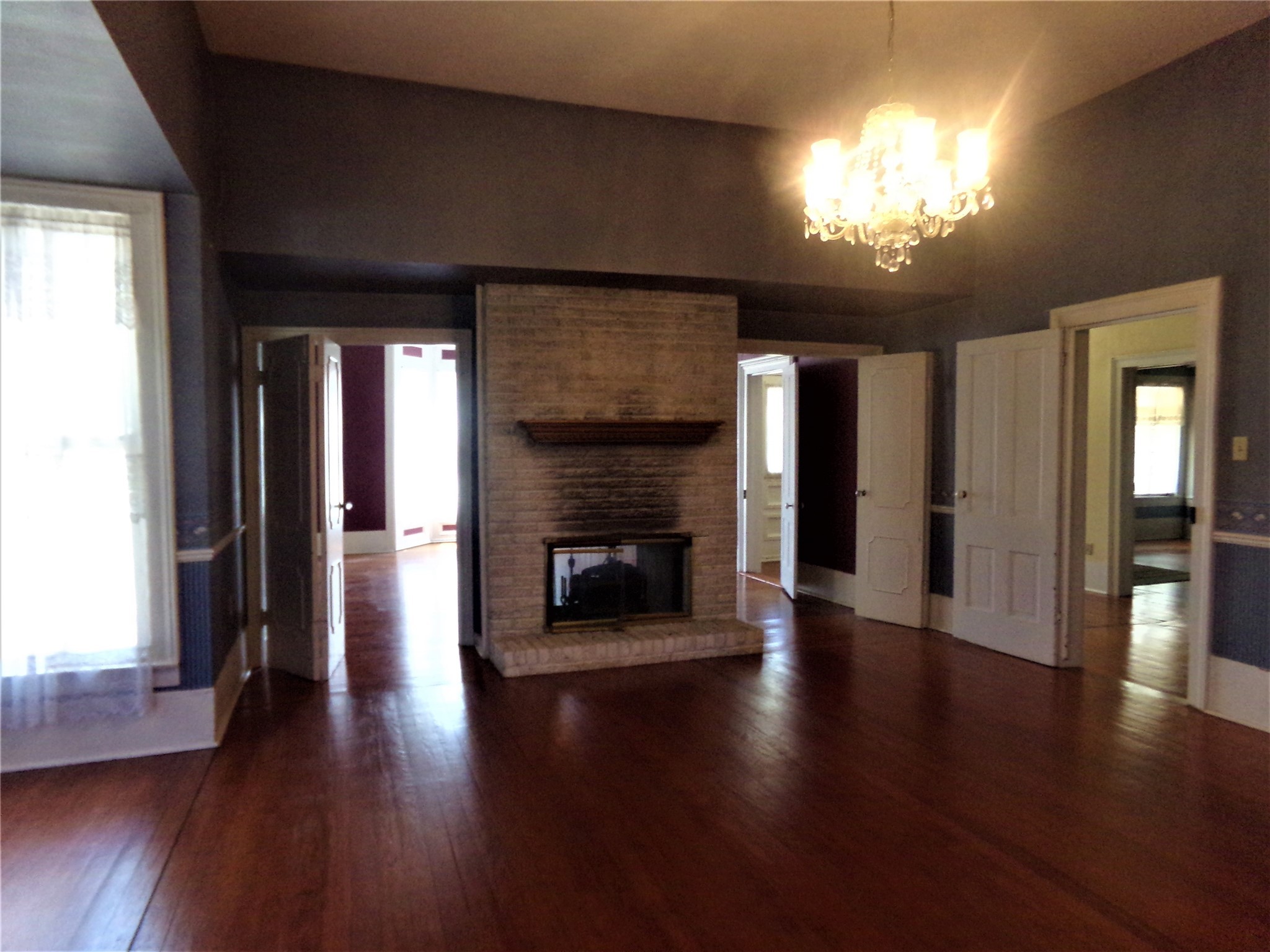 300 South Summit Street Weimar, TX 78962 - Photo 10 of 27 an empty room with wooden floor fireplace and windows