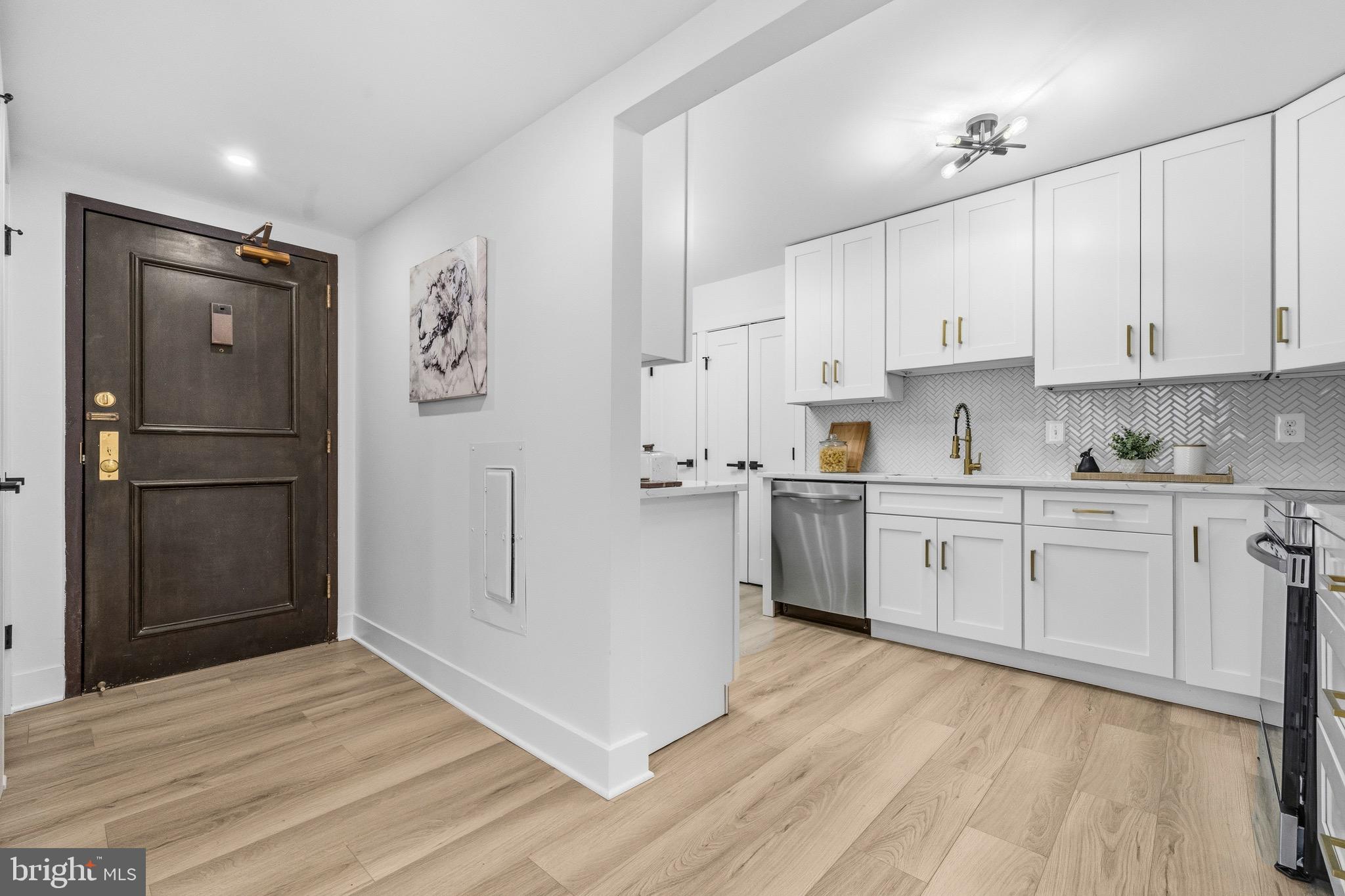 a kitchen with white cabinets and stainless steel appliances