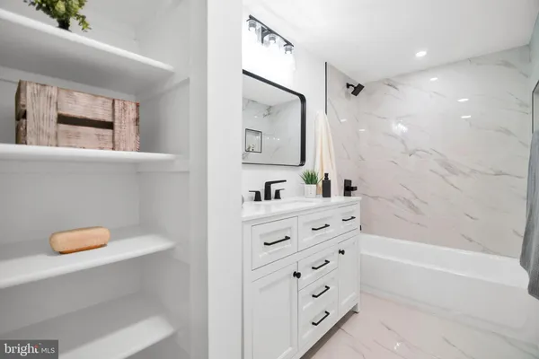 a bathroom with a granite countertop sink mirror vanity and toilet