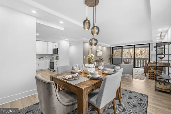 a dining room with wooden floor a chandelier a wooden table and chairs