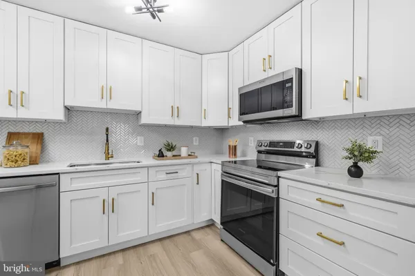a kitchen with granite countertop a sink stainless steel appliances and cabinets