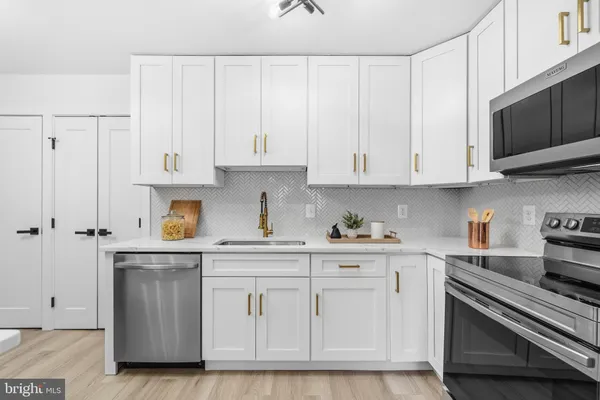 a kitchen with white cabinets and appliances