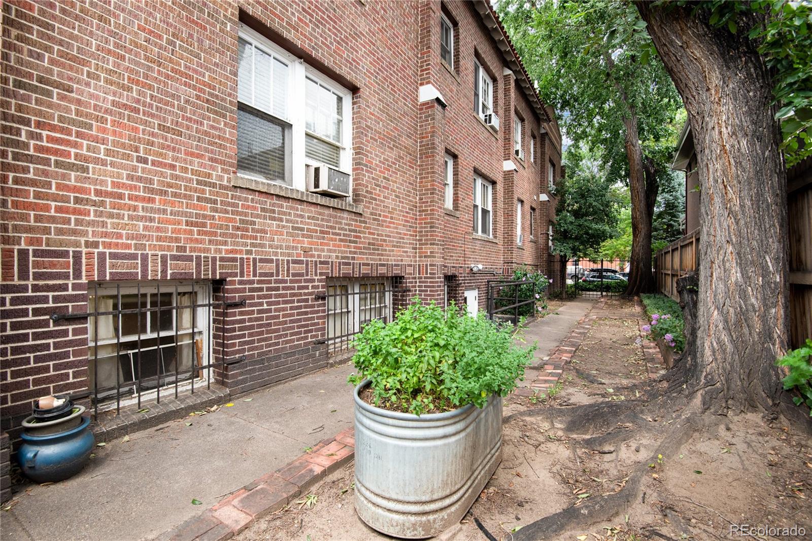 931 Emerson Street, Unit 1 Denver, CO 80218 - Photo 21 of 22 a view of a street with potted plants and a bench