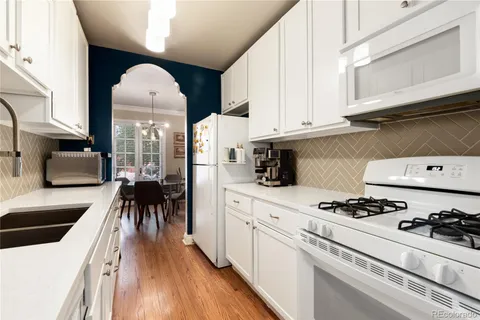 a kitchen with stainless steel appliances a white stove top oven and a sink with cabinets
