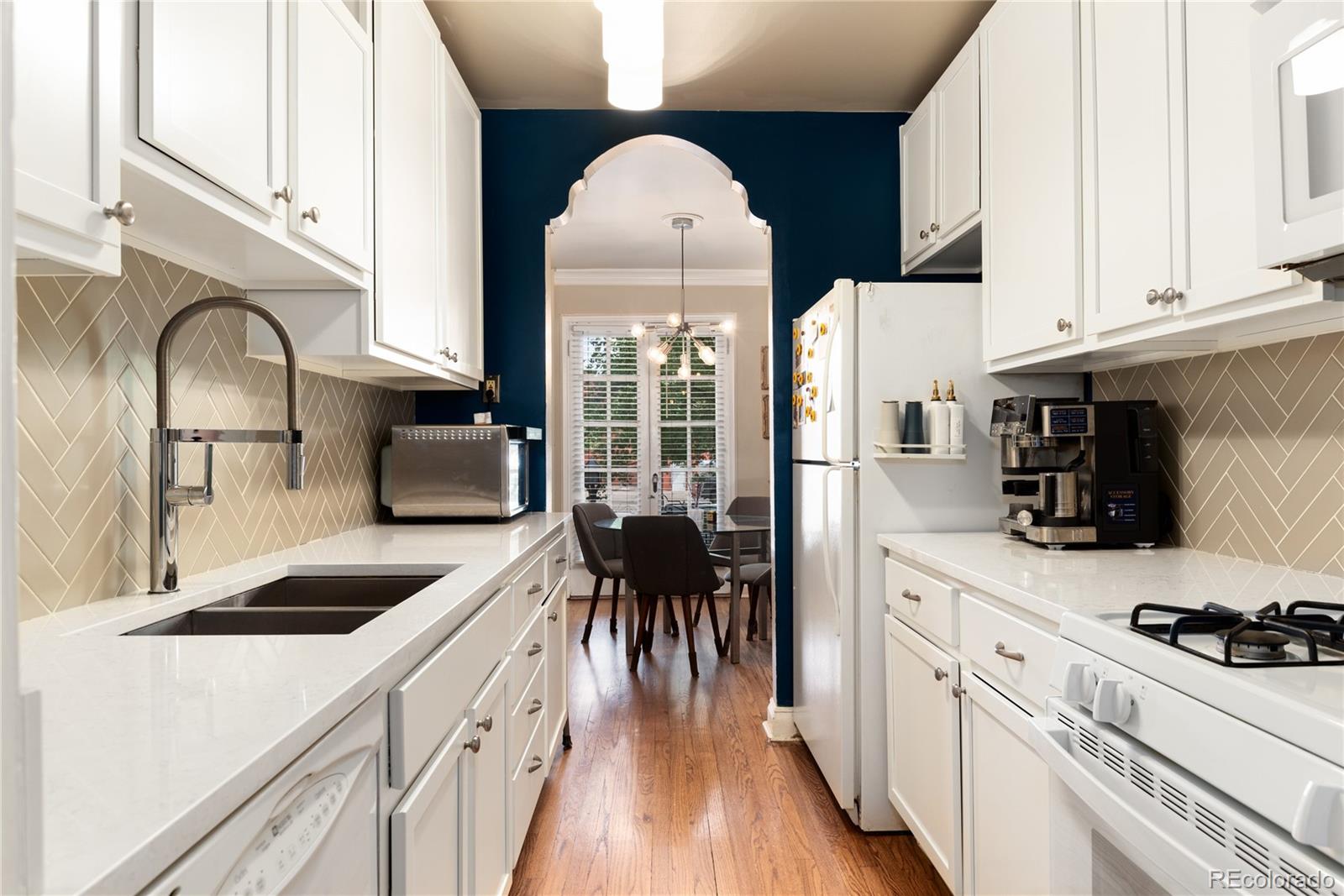 931 Emerson Street, Unit 1 Denver, CO 80218 - Photo 5 of 22 a kitchen with granite countertop a sink a counter space appliances and cabinets