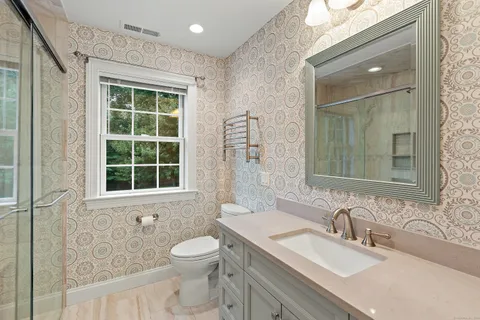 a bathroom with a granite countertop sink toilet and shower