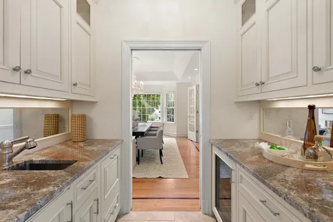 a kitchen with granite countertop a sink and white cabinets