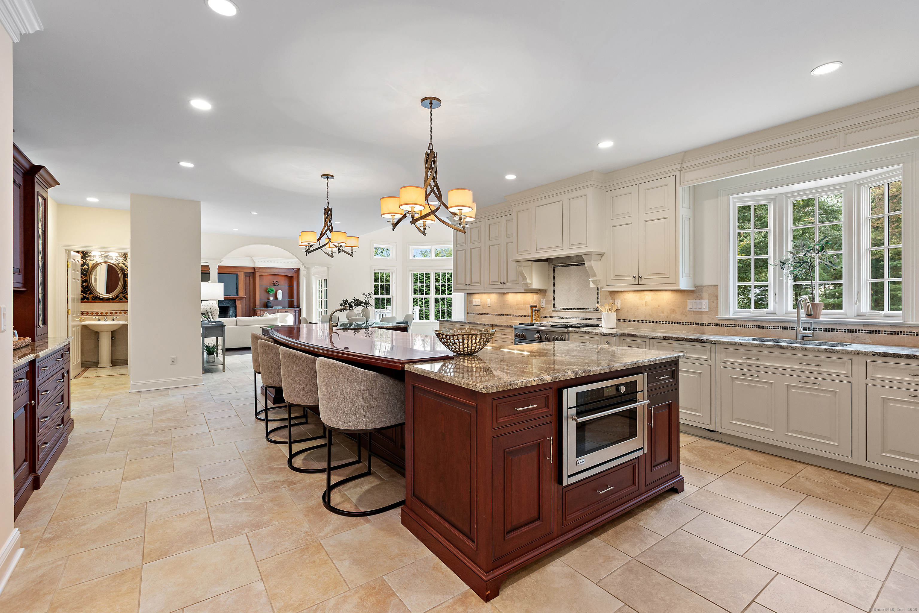 113 Skyview Lane New Canaan, CT 06840 - Photo 10 of 40 a kitchen with kitchen island granite countertop a stove a sink a dining table and chairs