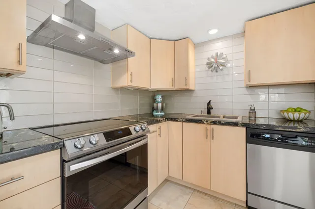 a kitchen with stainless steel appliances granite countertop a sink stove and cabinets