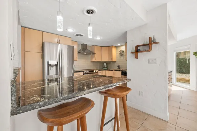 a kitchen with stainless steel appliances granite countertop a sink and a refrigerator